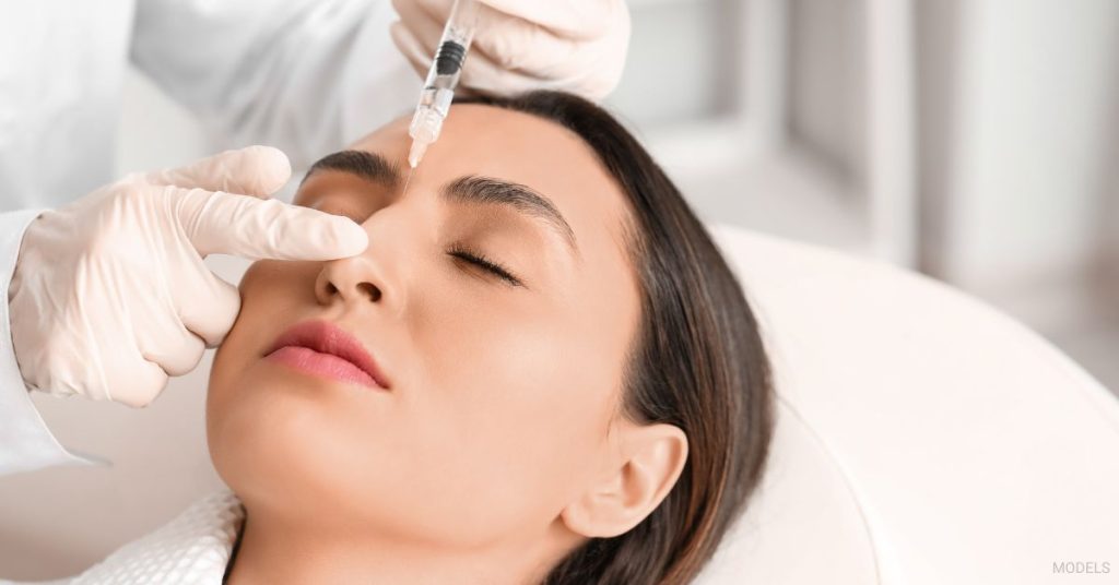 A woman getting nose fillers by a doctor. (Models)