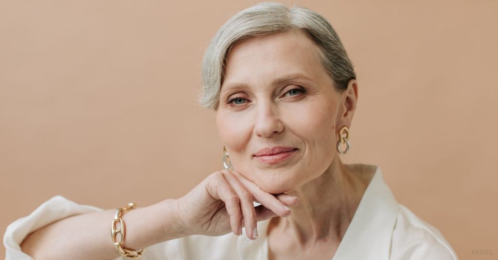 A mature woman with their hand on their chin. (Model)